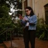 adult checking smartphone on front steps