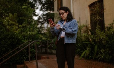 adult checking smartphone on front steps