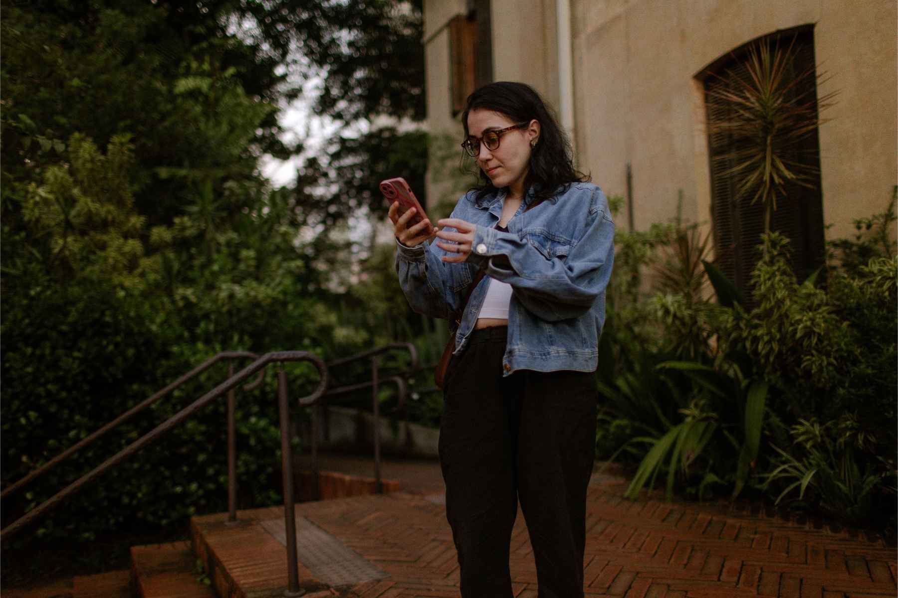 adult checking smartphone on front steps